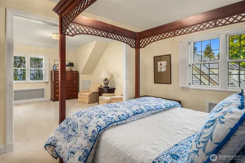 a bedroom with furniture and a large window