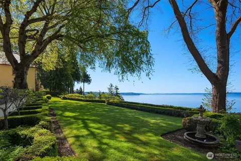 a front view of a house with a big yard and potted plants