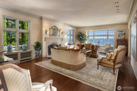 a living room with furniture large window and wooden floor