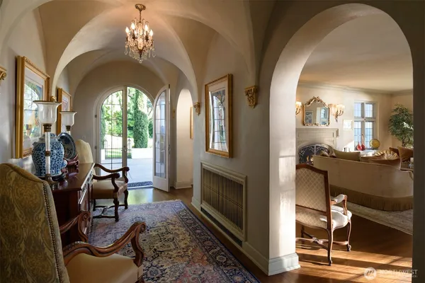 a living room with furniture a fireplace and a chandelier