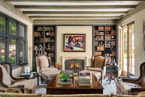 a living room with furniture a bookshelf and a large window