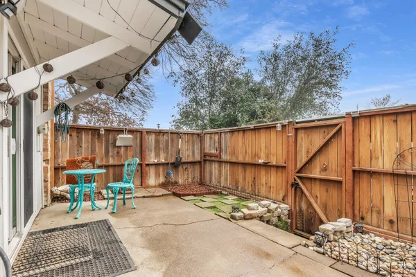 a backyard of a house with table and chairs