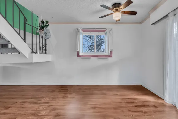 a kitchen with white cabinets and wooden floor