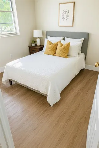 a bedroom with a bed and wooden floor
