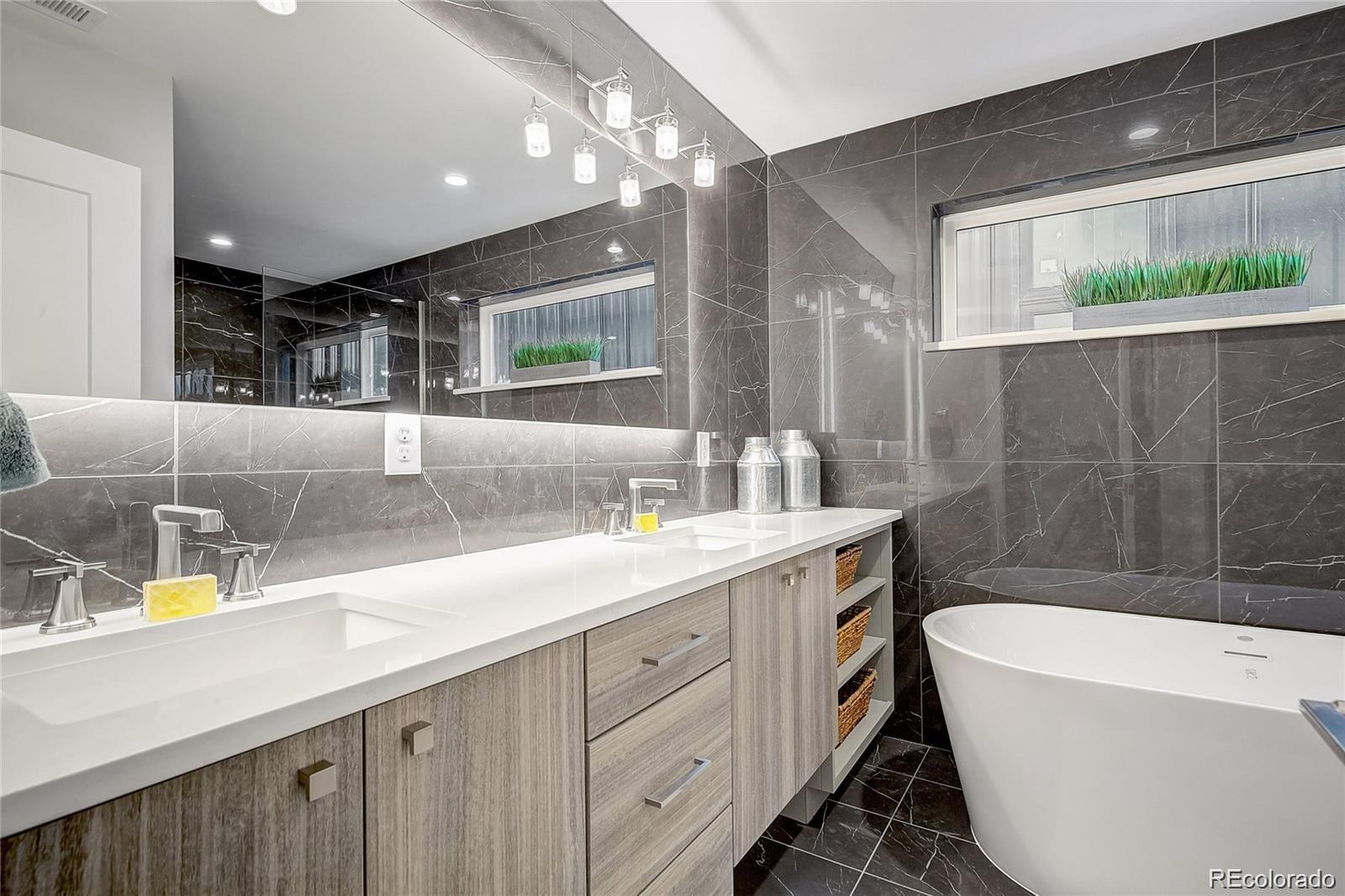 1811 West 32nd Avenue, Unit R Denver, CO 80211 - Photo 14 of 40 a bathroom with a double vanity sink a mirror and a bathtub