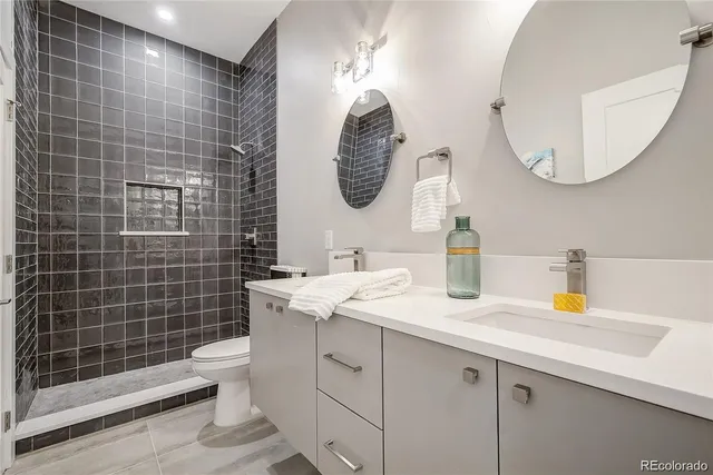 a bathroom with a double vanity sink mirror and toilet