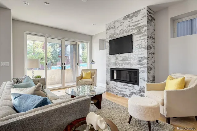 a living room with furniture a flat screen tv and a fireplace