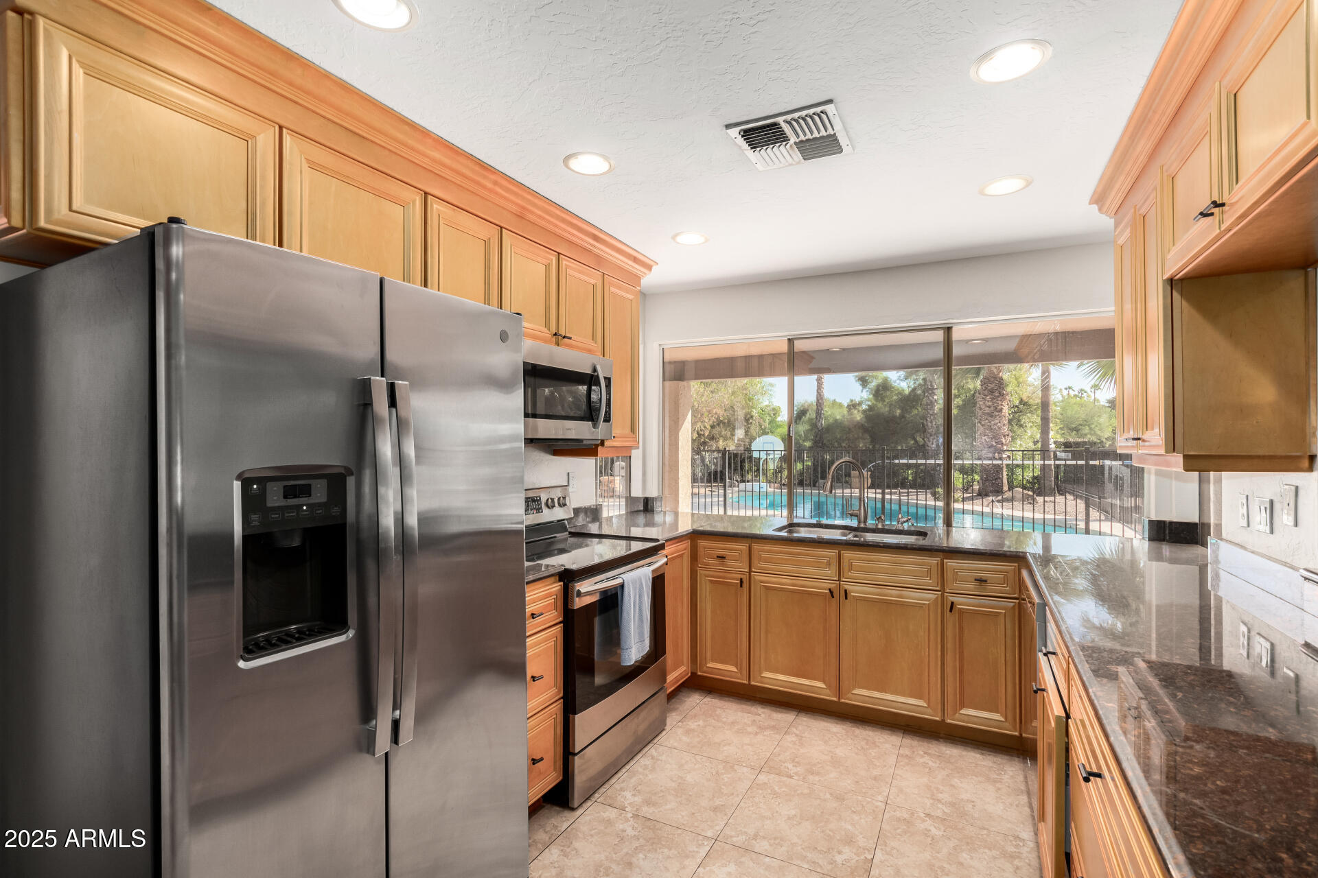 5739 East Cactus Road Scottsdale, AZ 85254 - Photo 11 of 52 a kitchen with stainless steel appliances granite countertop a refrigerator a stove and a sink with cabinets