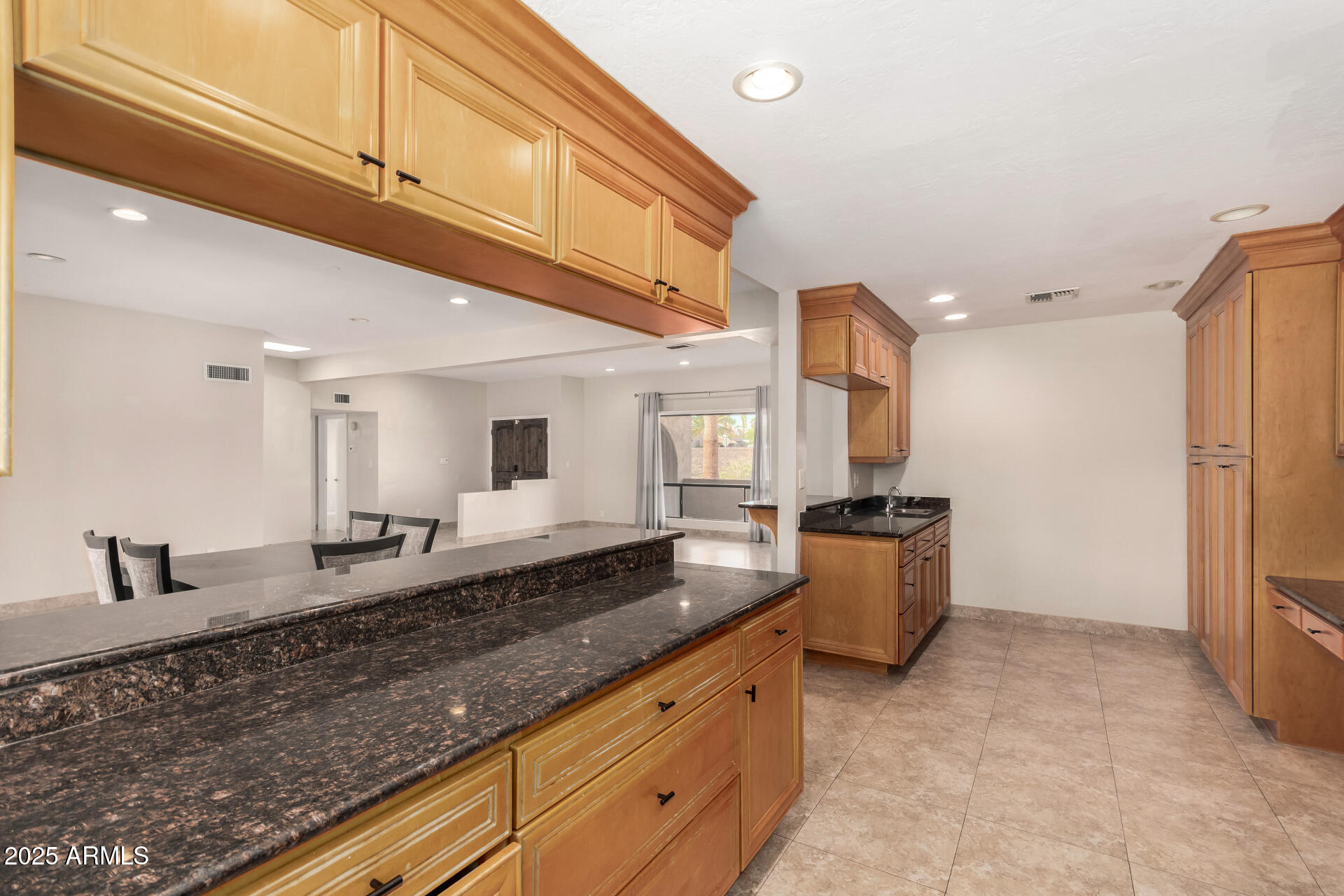 5739 East Cactus Road Scottsdale, AZ 85254 - Photo 12 of 52 a large kitchen with stainless steel appliances a large counter top a stove a chimney a sink and a refrigerator