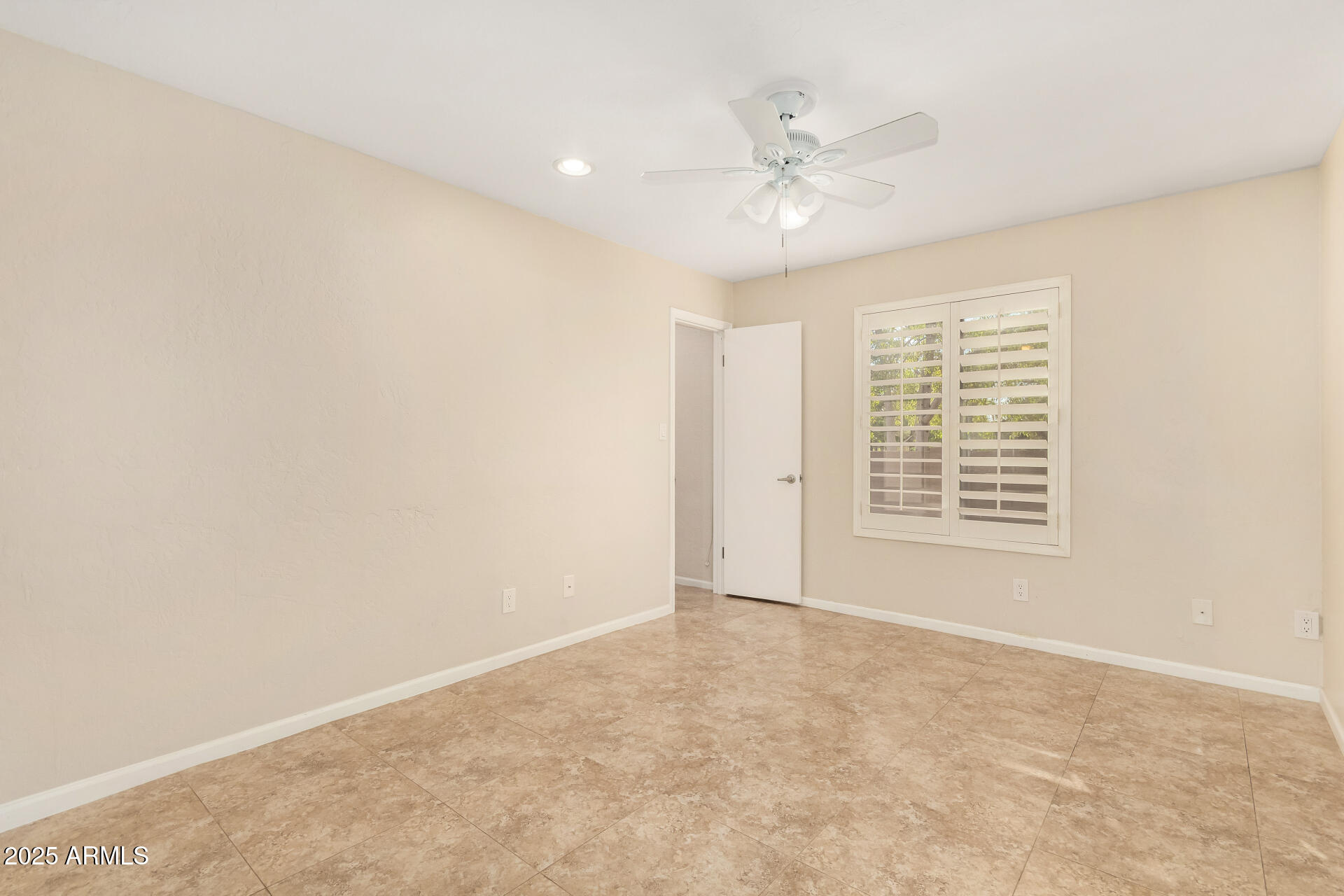 5739 East Cactus Road Scottsdale, AZ 85254 - Photo 30 of 52 an empty room with chandelier fan and windows