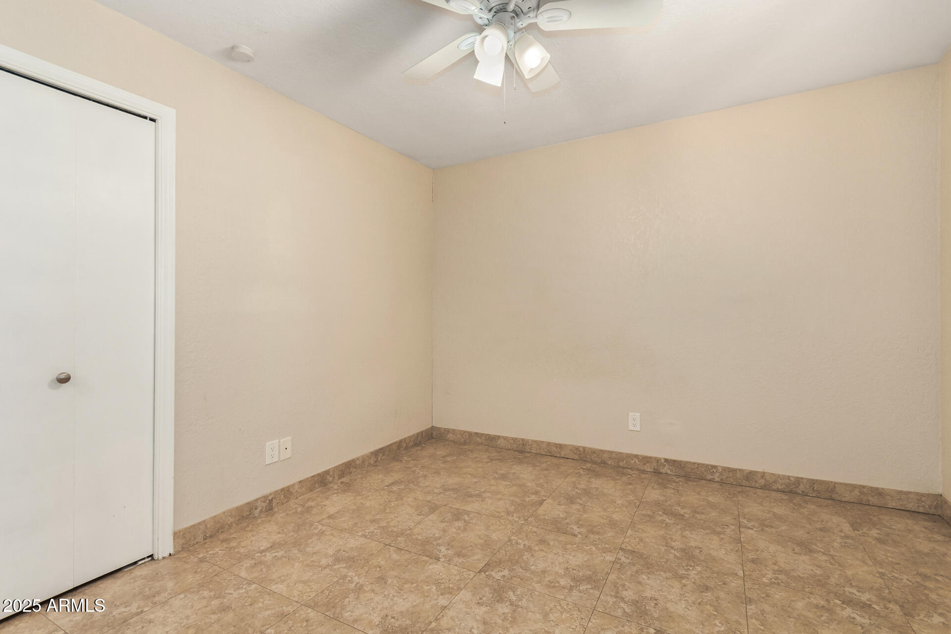 5739 East Cactus Road Scottsdale, AZ 85254 - Photo 34 of 52 an empty room with a chandelier fan