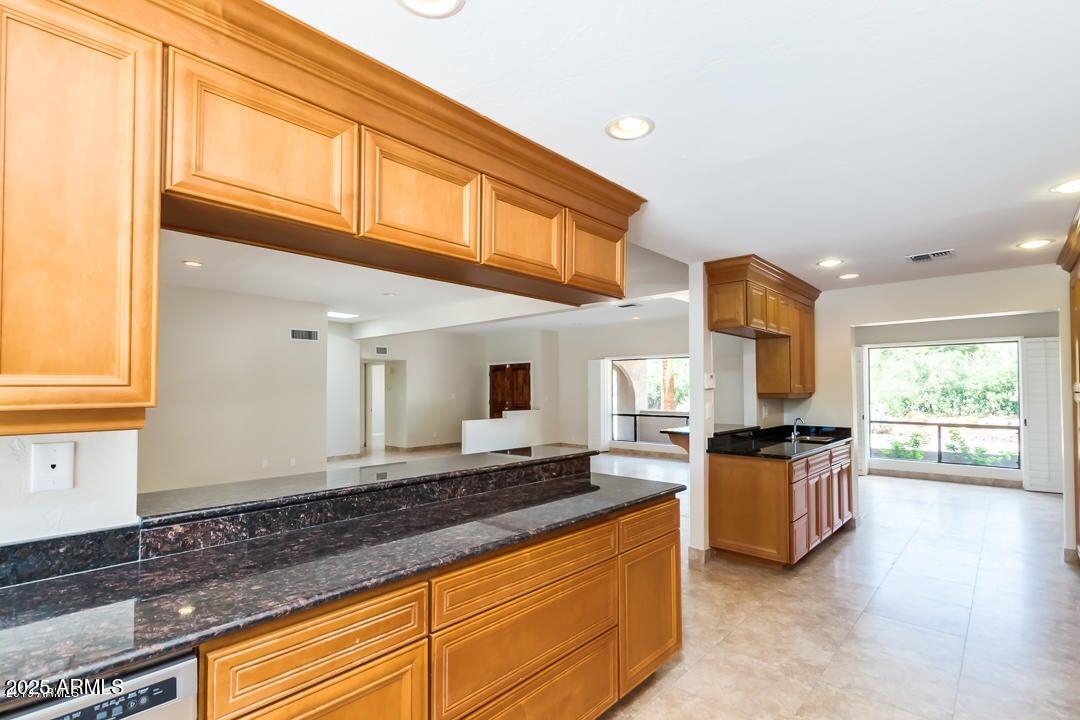 5739 East Cactus Road Scottsdale, AZ 85254 - Photo 48 of 52 a kitchen with granite countertop a stove a sink and a refrigerator
