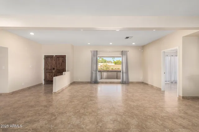 an empty room with a window and a kitchen
