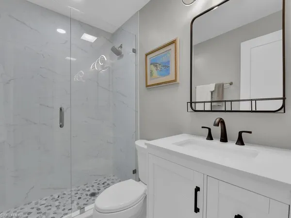 a bathroom with a sink a toilet and shower