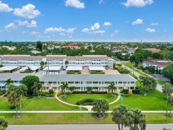 a view of a big house with a big yard and large trees