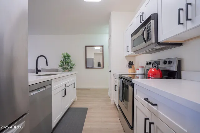 a kitchen with stainless steel appliances granite countertop a sink and cabinets