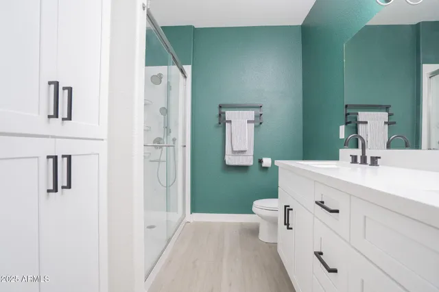 a bathroom with a granite countertop sink a mirror and a shower