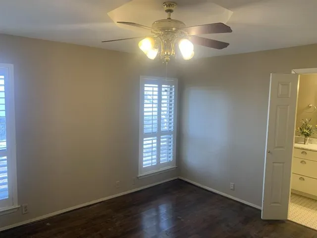 an empty room with wooden floor and windows in it