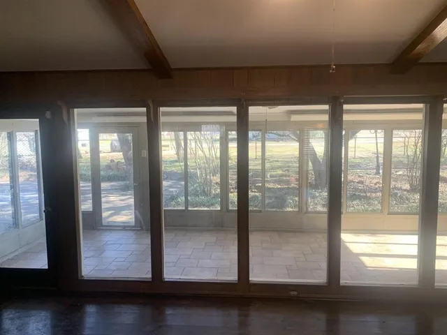 a room with wooden floor and windows