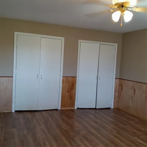 an empty room with wooden floor and hallway