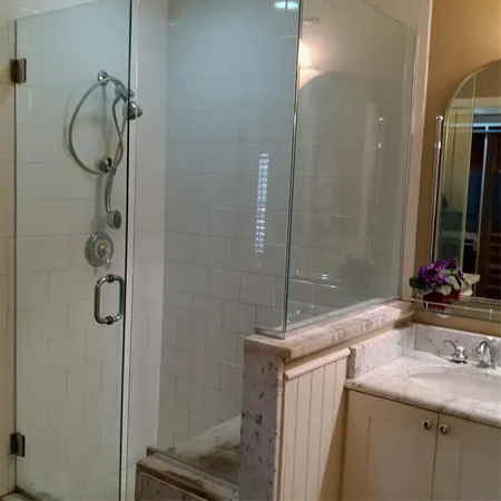 a bathroom with a granite countertop sink a mirror and a shower