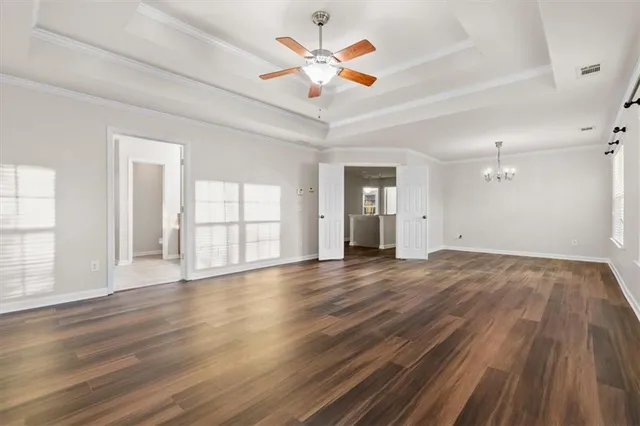 a view of an empty room with window and wooden floor