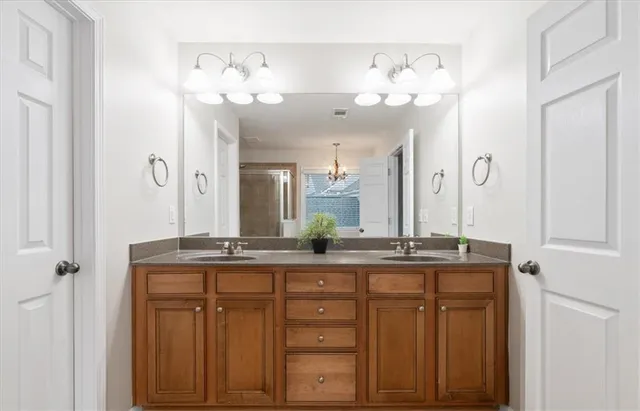 a bathroom with a granite countertop sink a large mirror and a shower