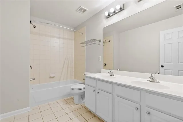 a bathroom with a double vanity sink mirror and toilet