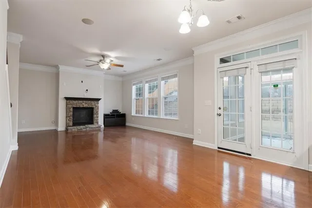 a view of a livingroom with wooden floor a ceiling fan and window