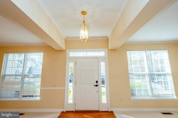 a view of a livingroom with a chandelier wooden floor and a chandelier