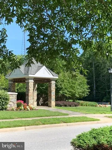 a view of a house with a yard and large trees