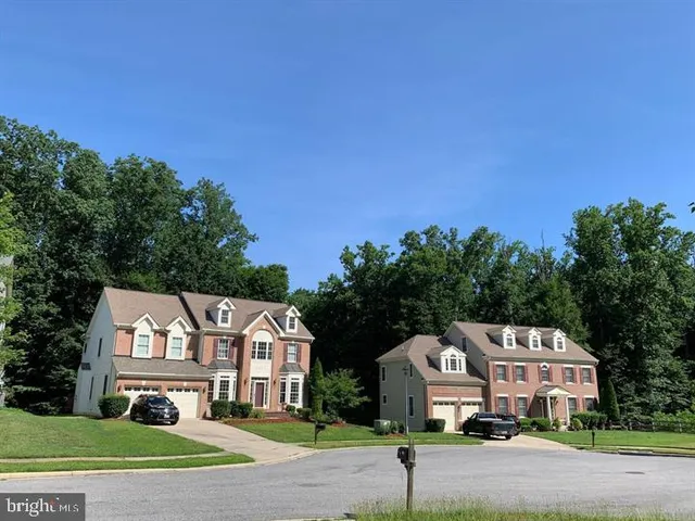 a front view of a house with a garden and trees
