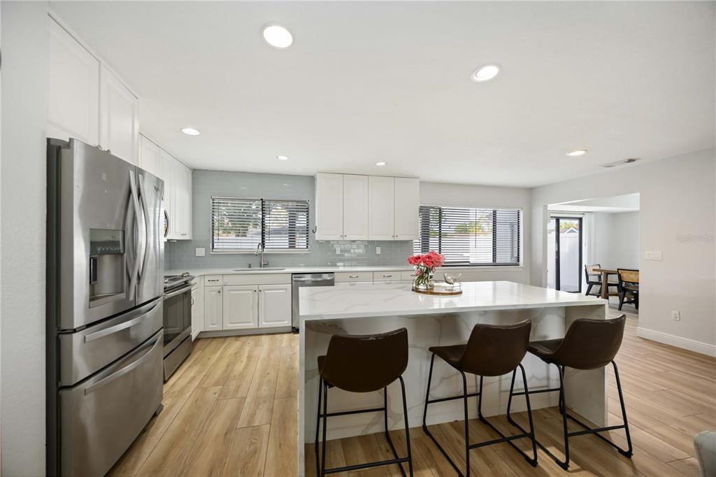 6775 Dennison Avenue North Port, FL 34287 - Photo 11 of 50 a kitchen with refrigerator and chairs