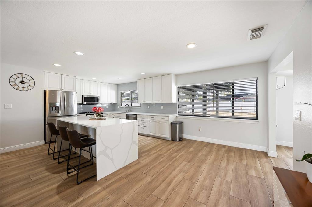 6775 Dennison Avenue North Port, FL 34287 - Photo 3 of 50 a kitchen with a sink a refrigerator and wooden floor