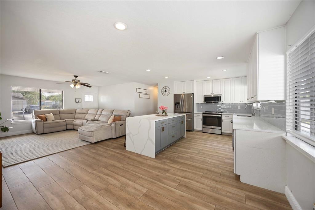 6775 Dennison Avenue North Port, FL 34287 - Photo 4 of 50 a large living room with stainless steel appliances kitchen island lots of furniture a sink a stove and a refrigerator