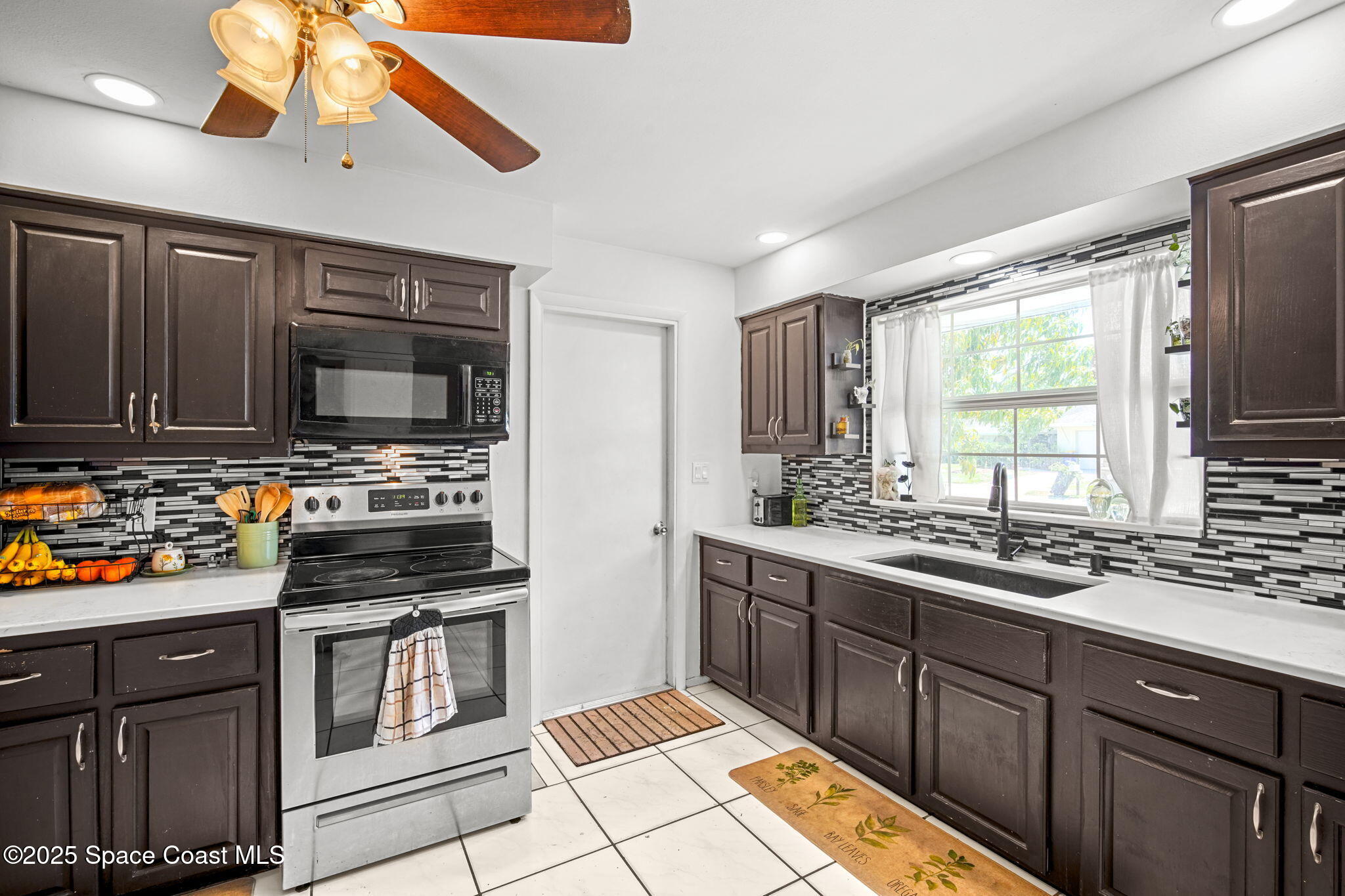 1044 Pompano Drive Rockledge, FL 32955 - Photo 11 of 28 a kitchen with stainless steel appliances a stove sink and microwave