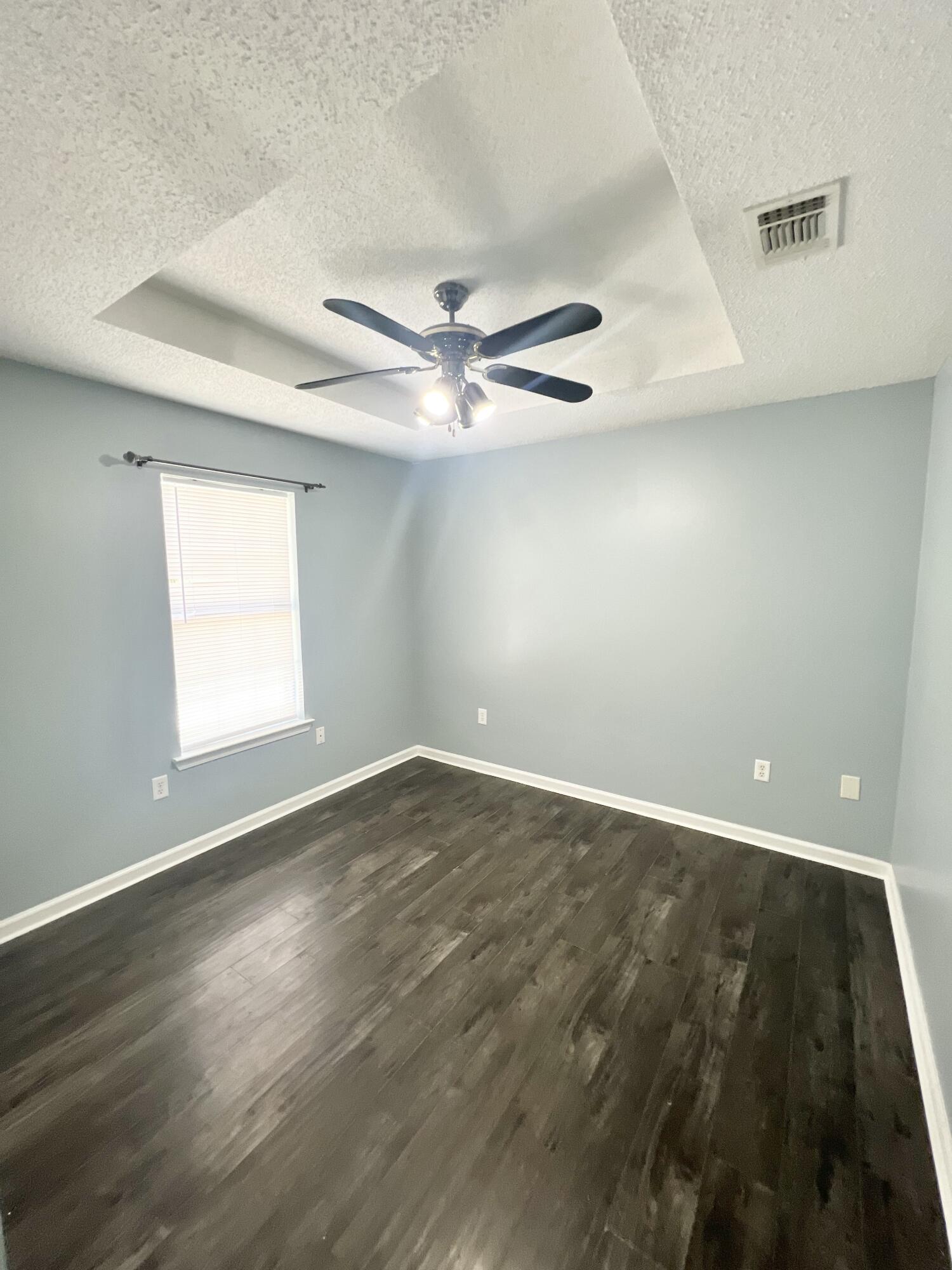 3429 Melissa Lane Crestview, FL 32539 - Photo 15 of 28 an empty room with wooden floor fan and windows