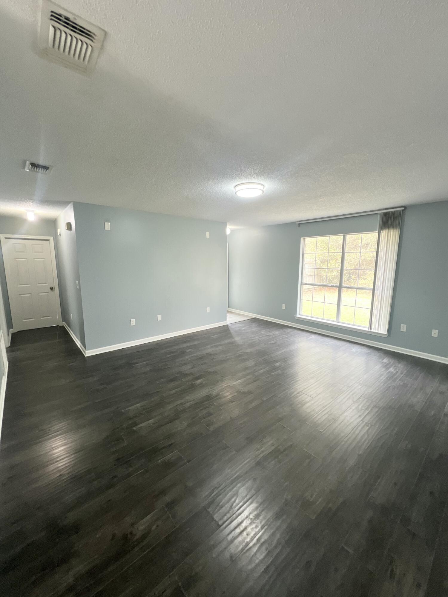 3429 Melissa Lane Crestview, FL 32539 - Photo 4 of 28 an empty room with wooden floor and windows