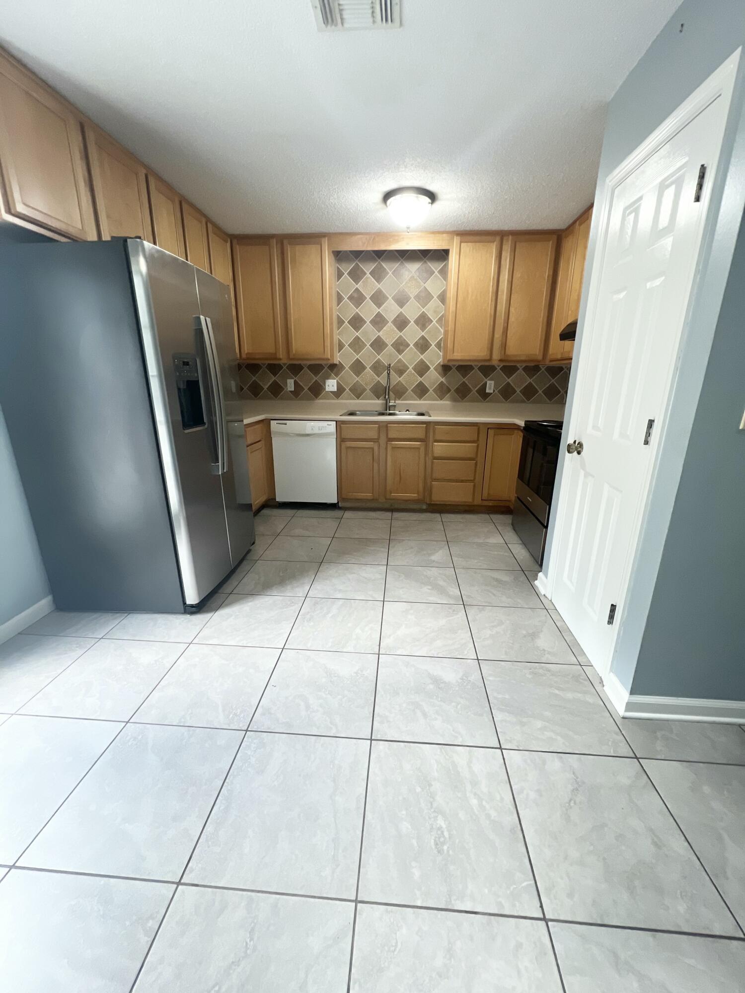 3429 Melissa Lane Crestview, FL 32539 - Photo 8 of 28 a kitchen with granite countertop a refrigerator a sink a stove a microwave and cabinets