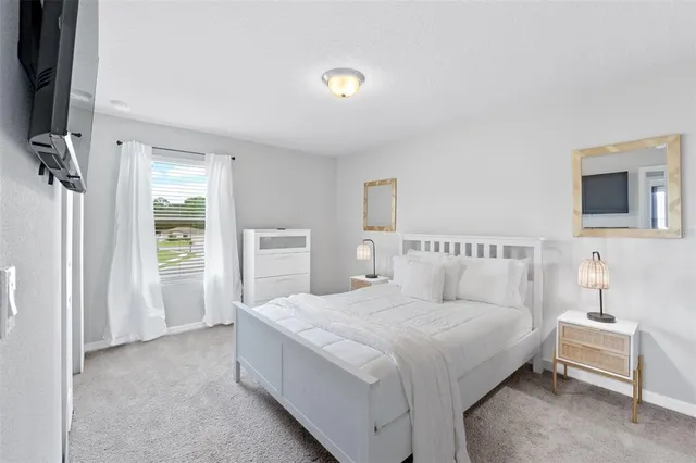 a bedroom with a large bed and large windows