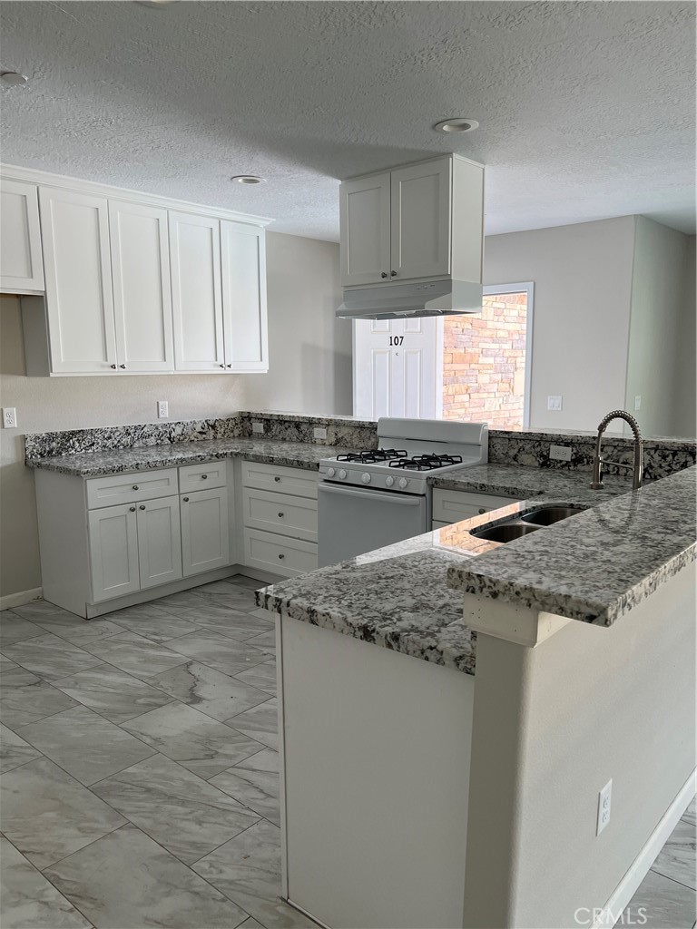 16550 Olive Street Hesperia, CA 92345 - Photo 4 of 9 a kitchen with stainless steel appliances granite countertop a sink stove and cabinets