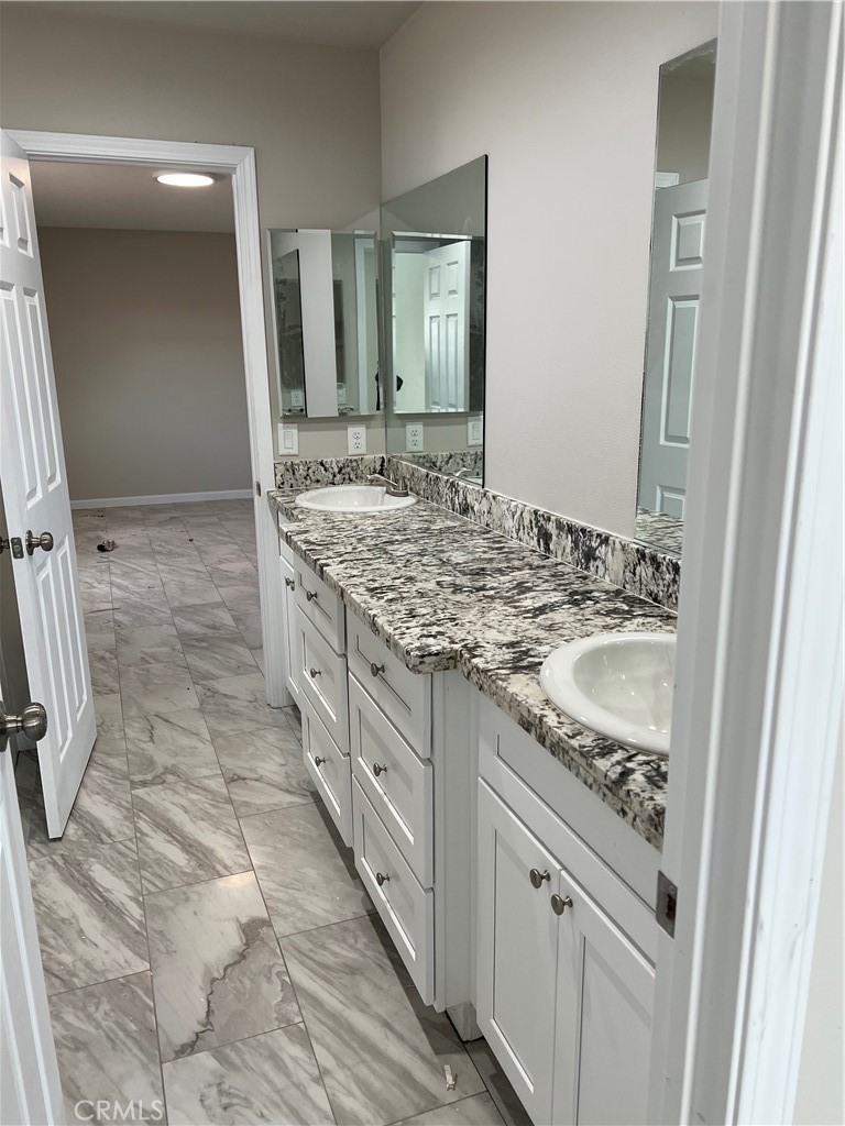 16550 Olive Street Hesperia, CA 92345 - Photo 7 of 9 a bathroom with a granite countertop sink a mirror and a
