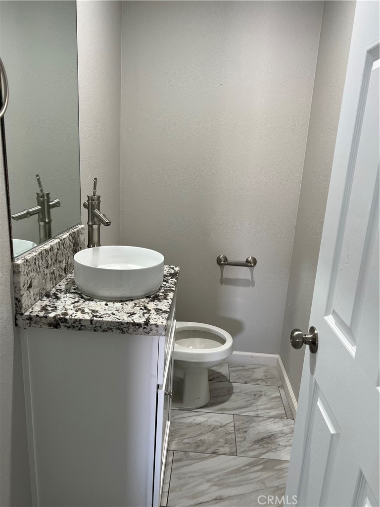 16550 Olive Street Hesperia, CA 92345 - Photo 9 of 9 a bathroom with a granite countertop sink toilet and a mirror
