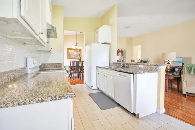 a kitchen with stainless steel appliances granite countertop a sink and a refrigerator