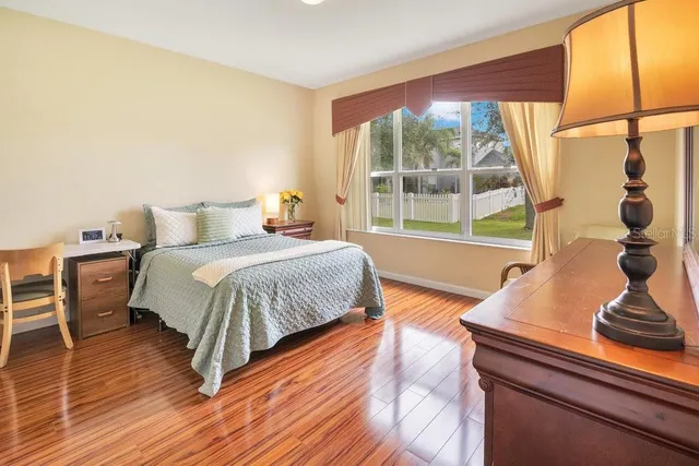 a bedroom with a bed and wooden floor
