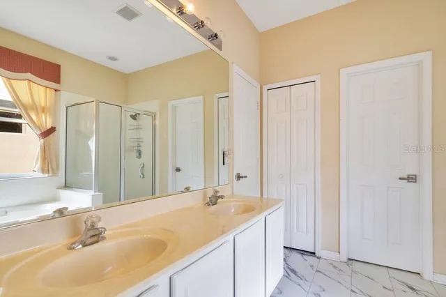 a bathroom with a double vanity sink and a mirror