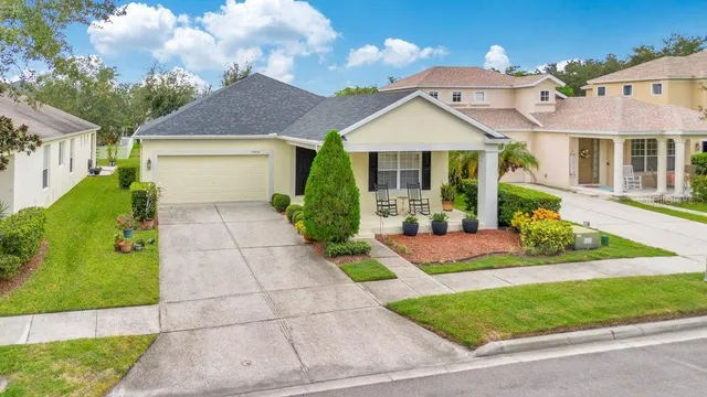 a front view of a house with a yard and potted plants