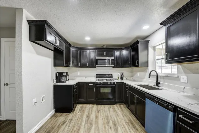 a kitchen with stainless steel appliances granite countertop a sink stove and refrigerator