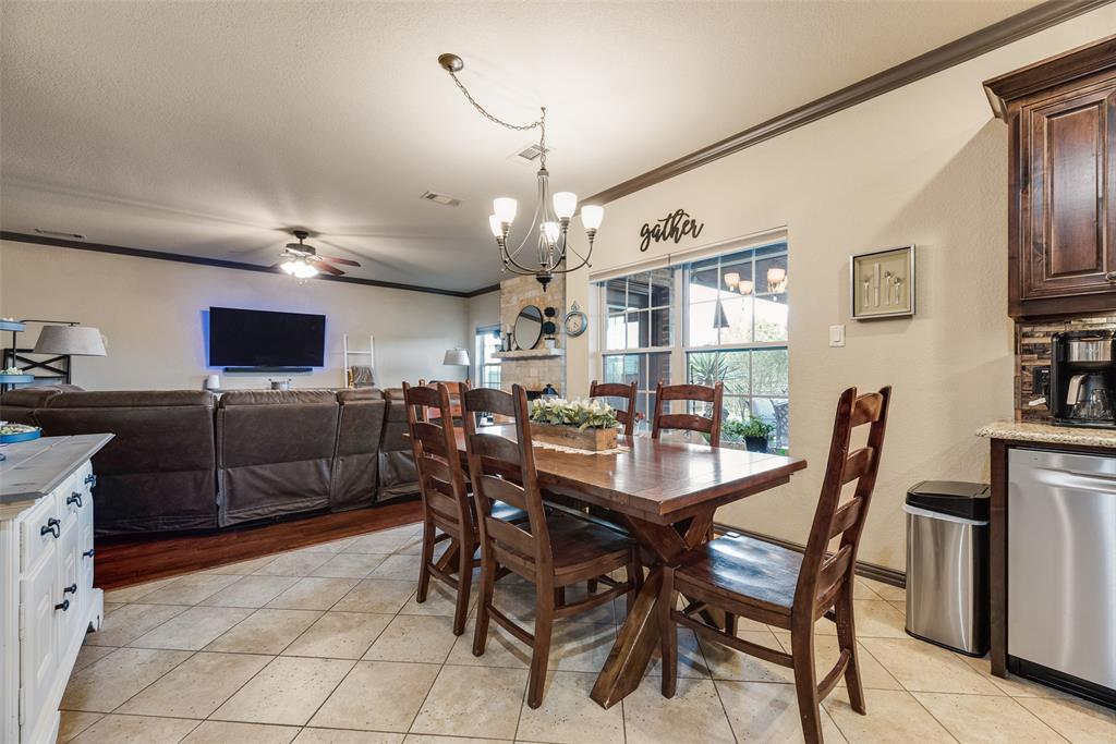1132 Chartres Street Kaufman, TX 75142 - Photo 10 of 25 Open-concept dining and living area featuring tile flooring, a dark wood dining table, and a contemporary chandelier