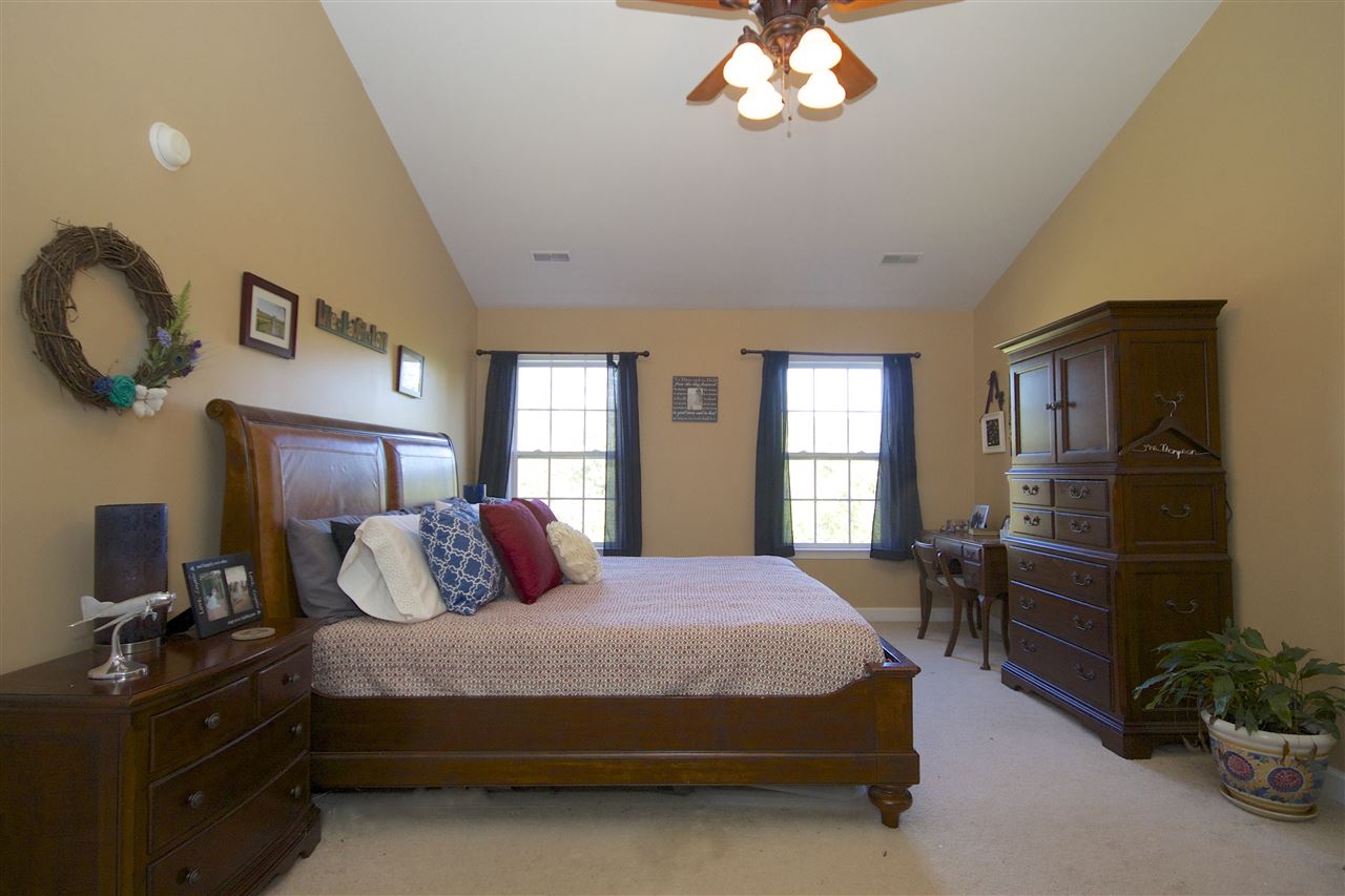33 Haversack Road Palmyra, VA 22963 - Photo 13 of 22 a bedroom with a large bed and a chandelier